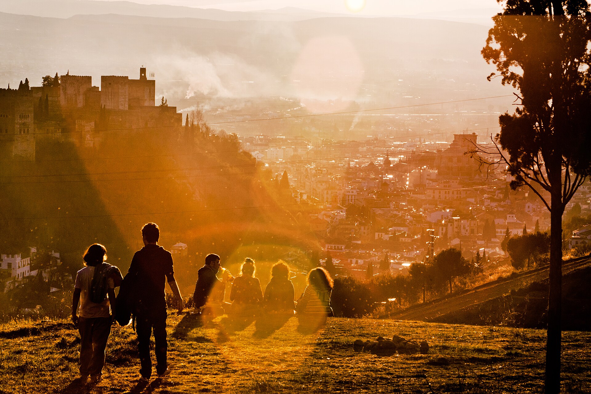 Vista urbana ao entardecer com pessoas em primeiro plano